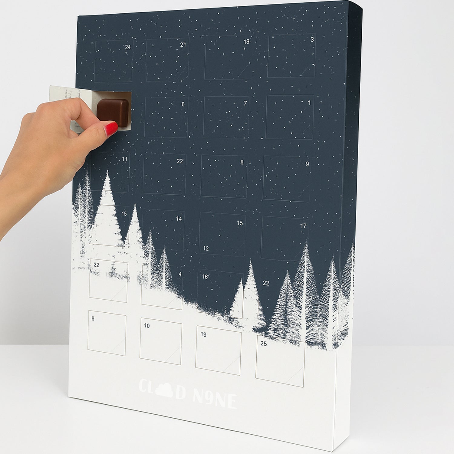 Custom print Advent calendar with snowy forest design, hand opening a door.